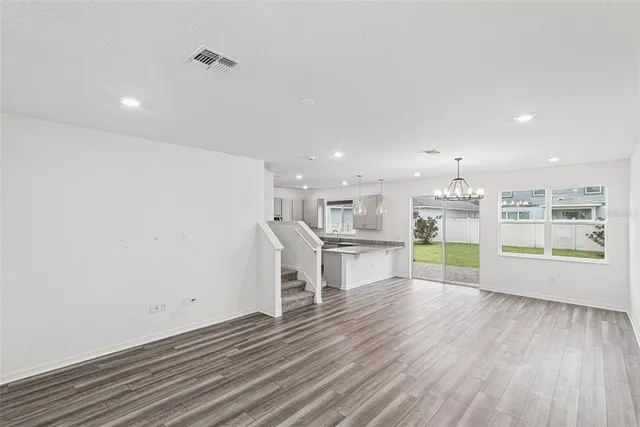 a view of kitchen with a sink wooden floor and a window