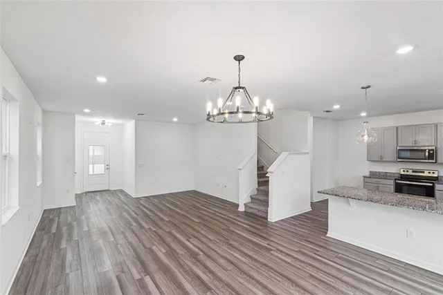 a view of a kitchen with wooden floor and stainless steel appliances