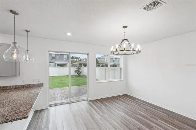 a view of wooden floor chandelier and windows in a room