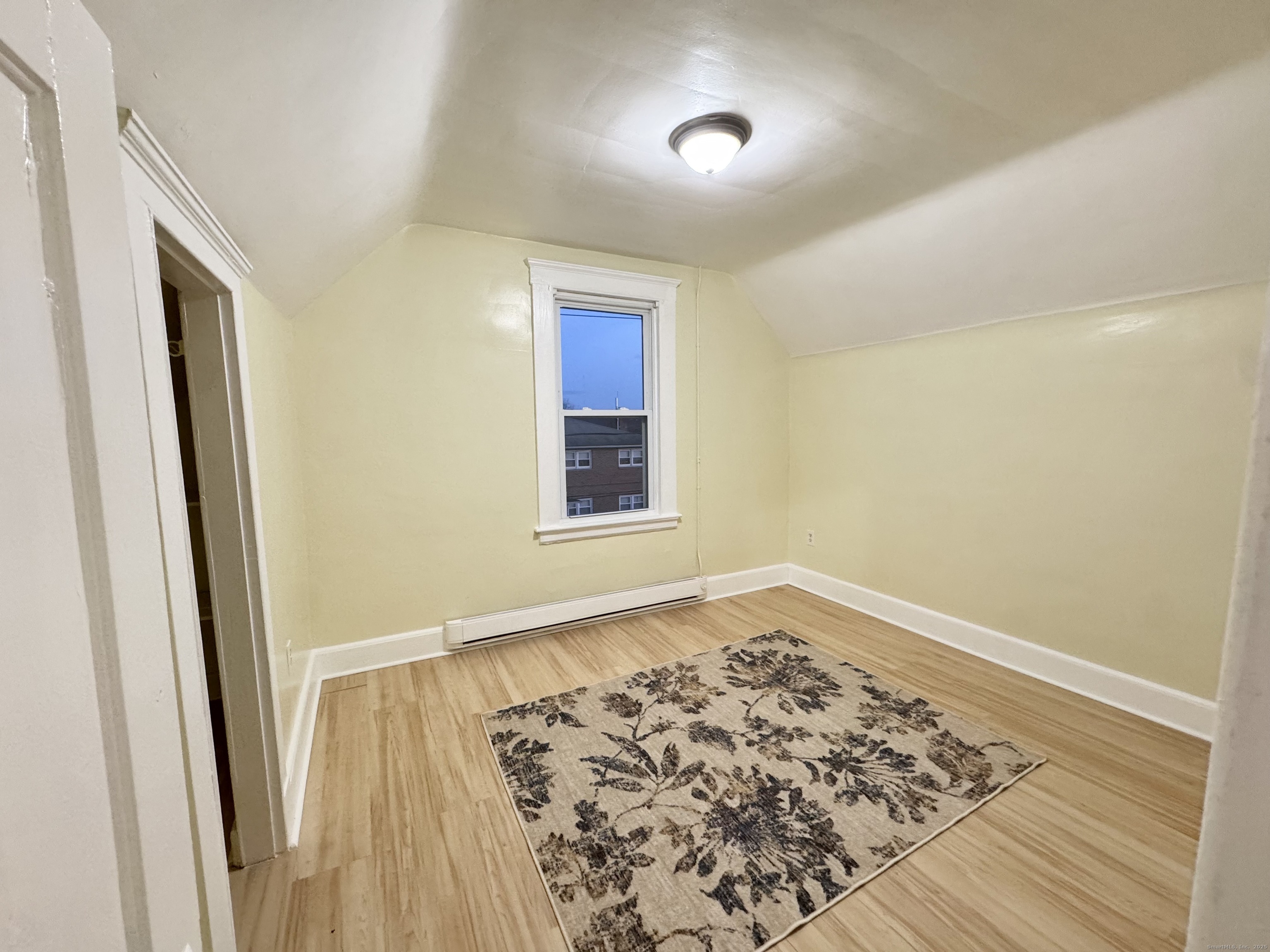 54 New Haven Avenue Waterbury, CT 06708 - Photo 6 of 9 an empty room with wooden floor and windows
