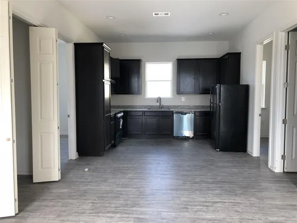 a kitchen with granite countertop stainless steel appliances a refrigerator and cabinets