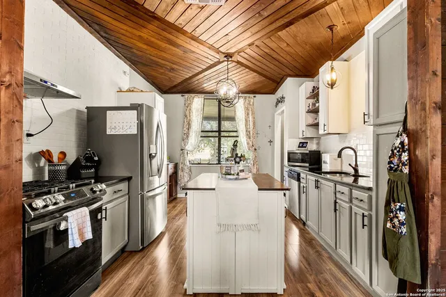 a kitchen with granite countertop a sink a counter top space and cabinets