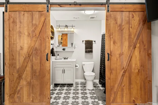 a bathroom with a sink vanity mirror and toilet