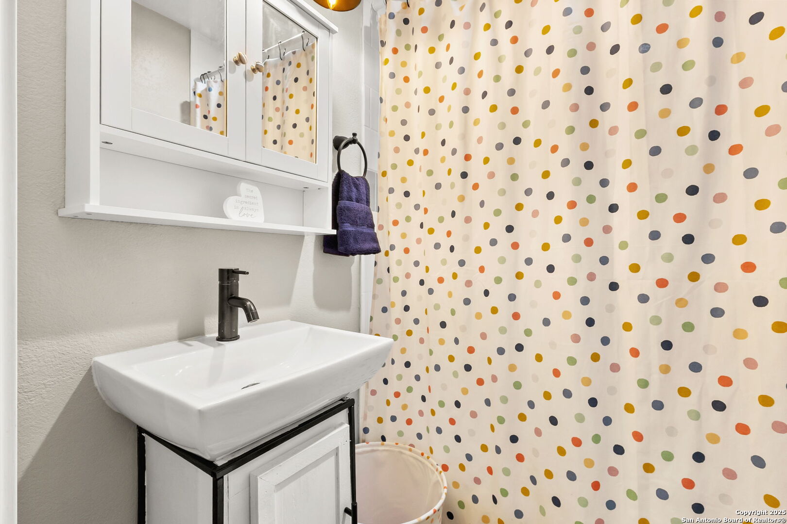 114 Avenue B Converse, TX 78109 - Photo 21 of 26 a bathroom with a sink a mirror and a shower curtain