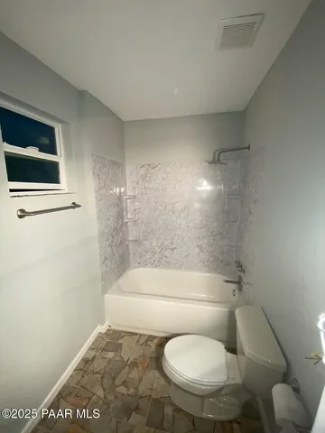 a bathroom with a toilet and a shower