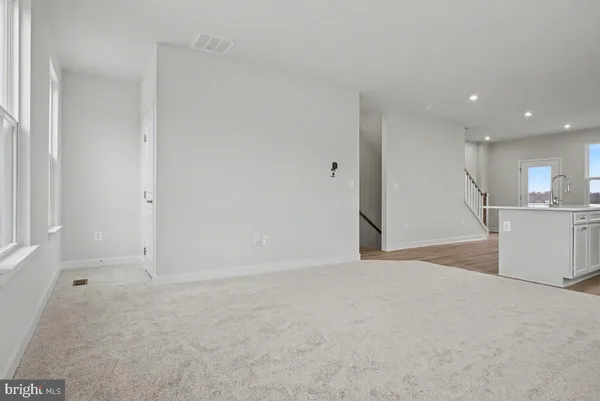 a view of an empty room with a kitchen
