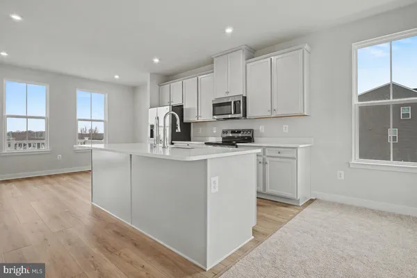 a kitchen with white cabinets and appliances