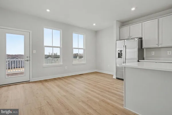a view of empty room with wooden floor and window