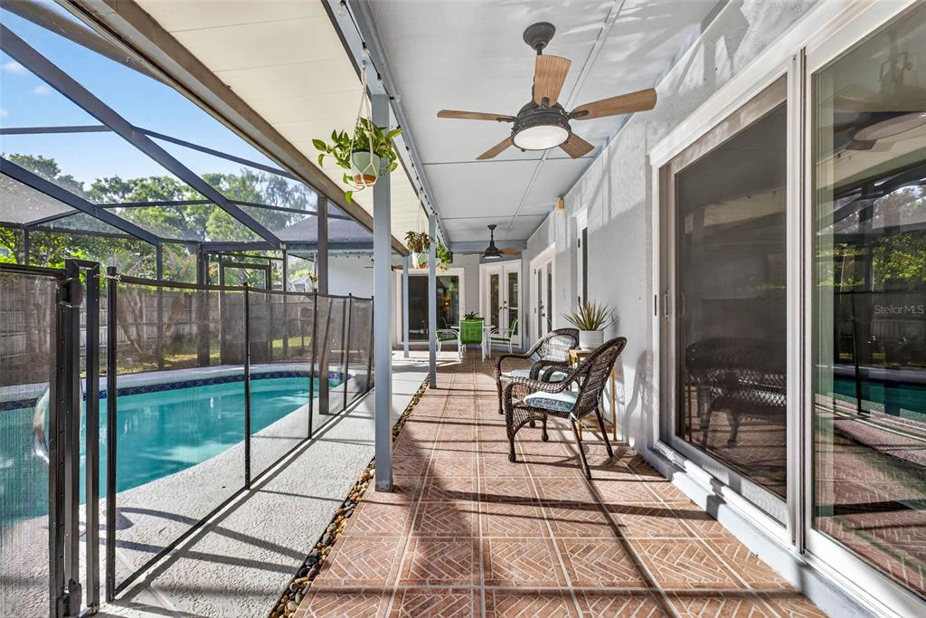12913 Rain Forest Street Temple Terrace, FL 33617 - Photo 3 of 63 a view of a patio with table and chairs potted plants with wooden floor and fence