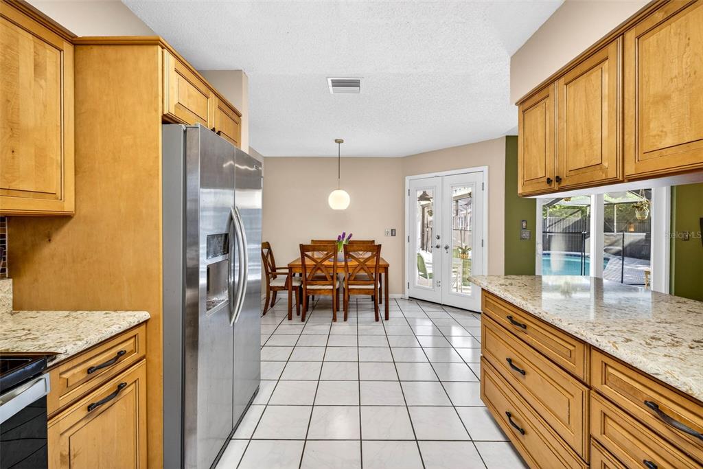12913 Rain Forest Street Temple Terrace, FL 33617 - Photo 31 of 63 a large kitchen with granite countertop a sink and a refrigerator