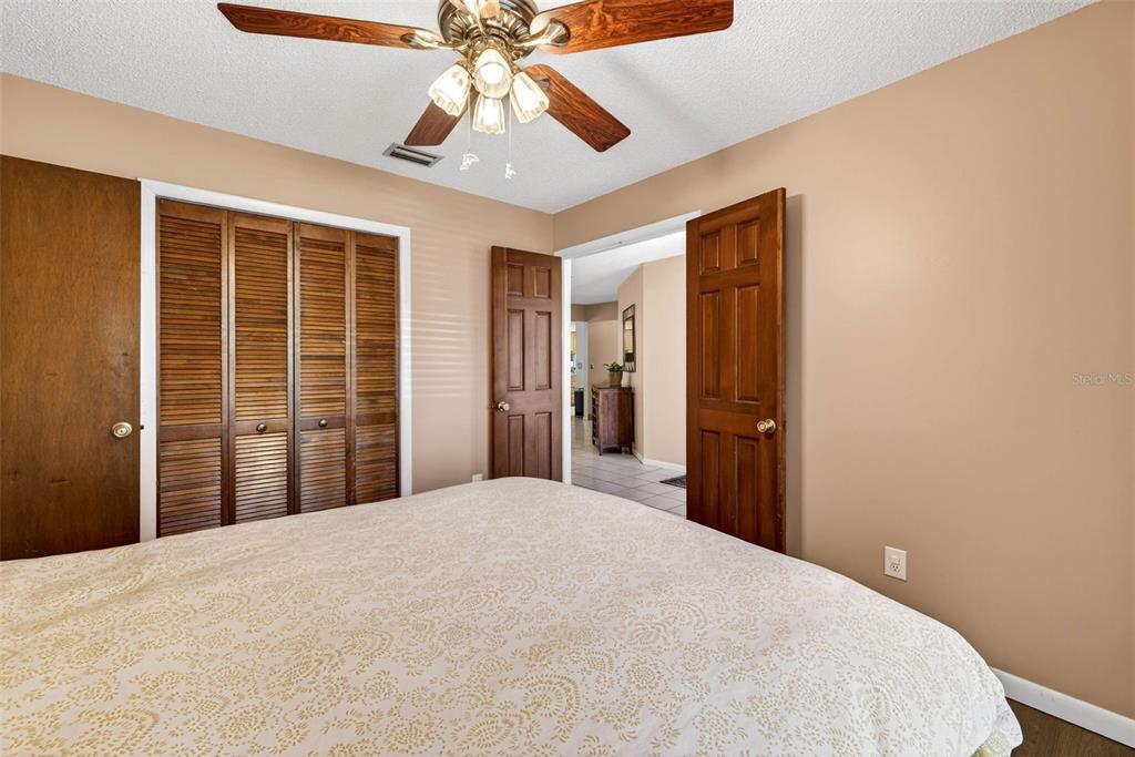 12913 Rain Forest Street Temple Terrace, FL 33617 - Photo 37 of 63 a bedroom with a large bed and a chandelier
