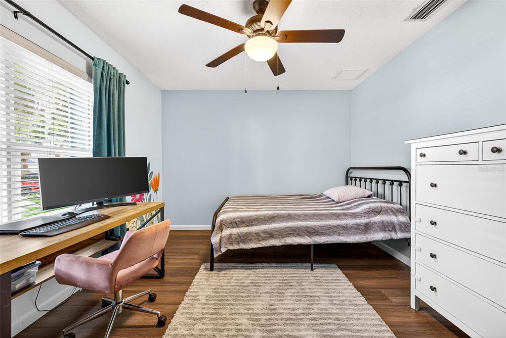 12913 Rain Forest Street Temple Terrace, FL 33617 - Photo 39 of 63 a bedroom with a bed and a computer on a desk next to a window