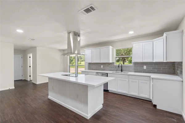 a kitchen with a sink cabinets and wooden floor