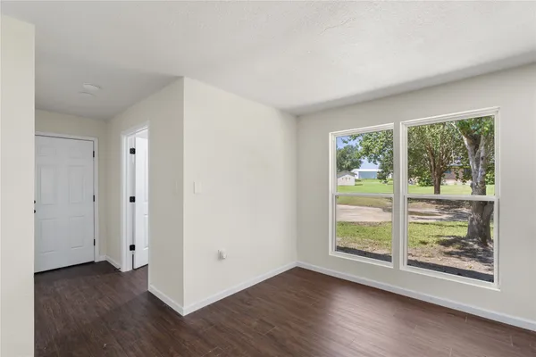a view of a room with wooden floor and window
