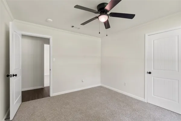 an empty room with closet and a chandelier fan