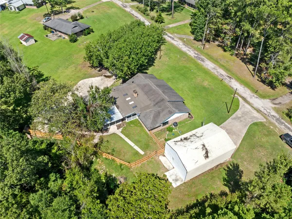 an aerial view of a house with a yard and greenery