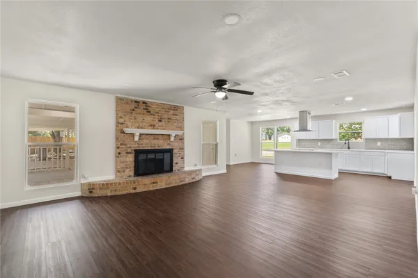 a view of an empty room with a fireplace and window