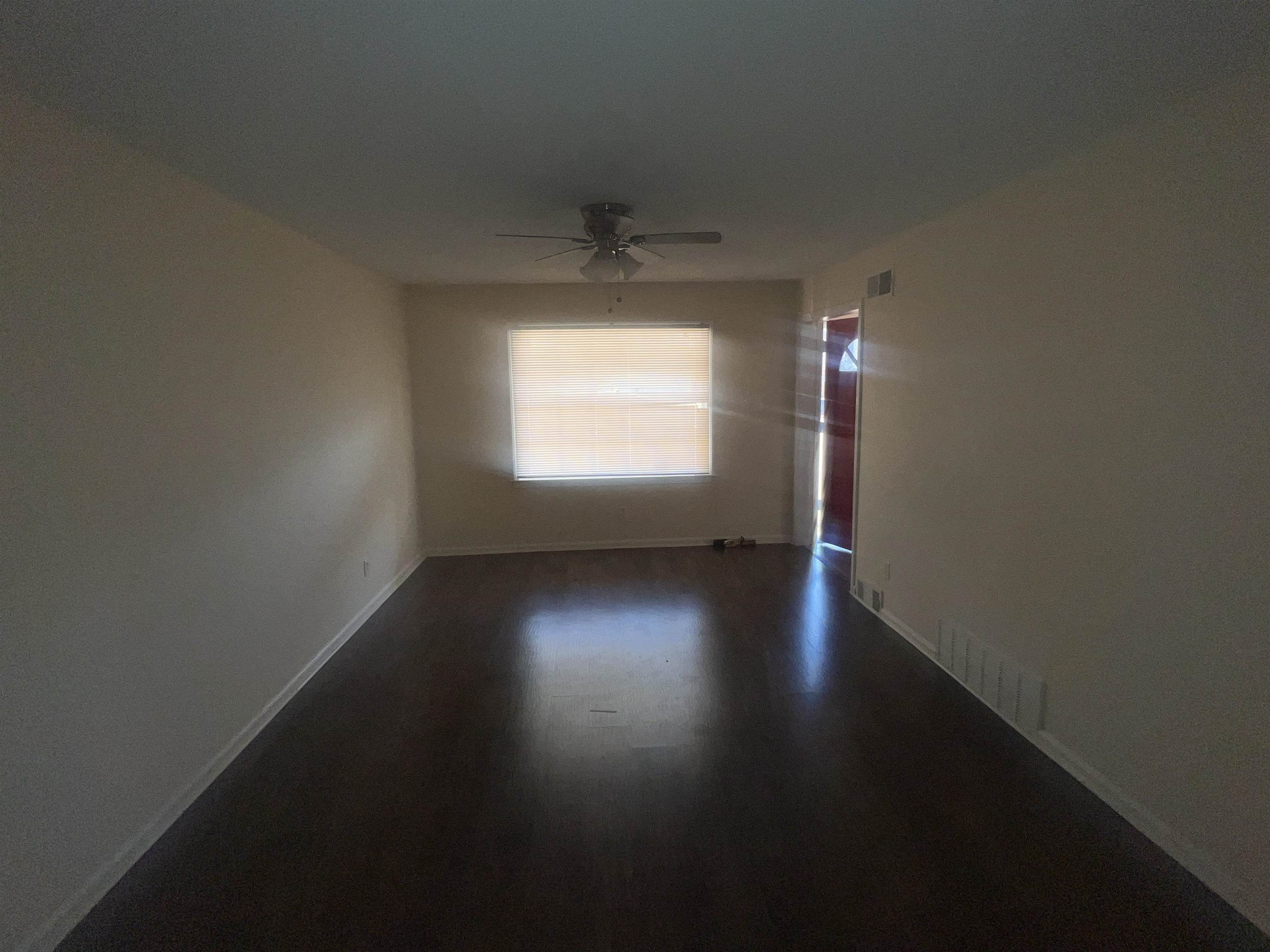 4295 Hudgins Road Memphis, TN 38116 - Photo 3 of 16 Spacious room featuring dark wood-finish flooring, light-toned walls, and a ceiling fan