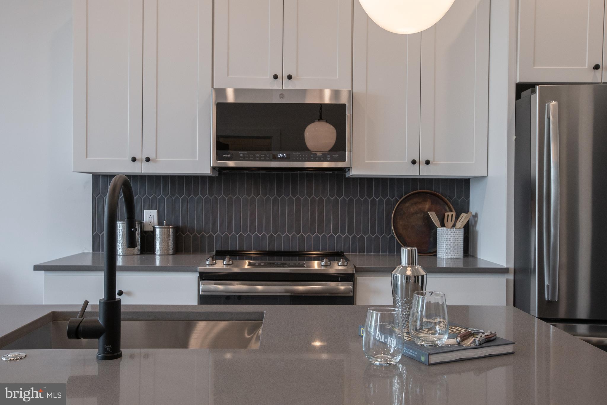 2940 West Thompson Street, Unit 305 Philadelphia, PA 19121 - Photo 17 of 24 a kitchen with stainless steel appliances granite countertop a stove and a refrigerator