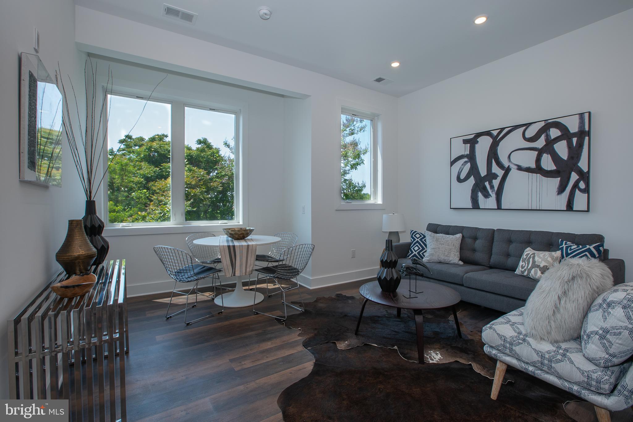 2940 West Thompson Street, Unit 305 Philadelphia, PA 19121 - Photo 2 of 24 a living room with furniture and floor to ceiling windows
