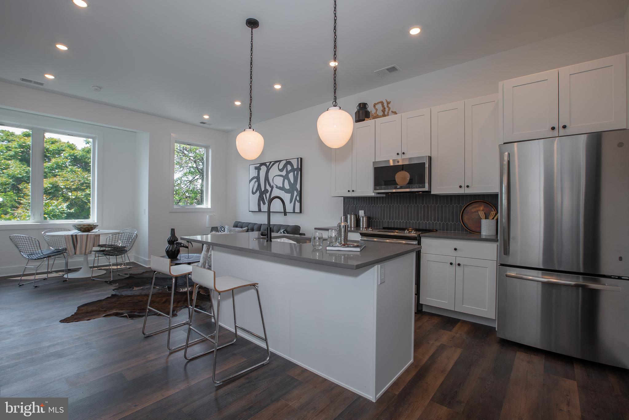 2940 West Thompson Street, Unit 305 Philadelphia, PA 19121 - Photo 4 of 24 a kitchen with stainless steel appliances granite countertop a sink a stove a refrigerator cabinets and living room view