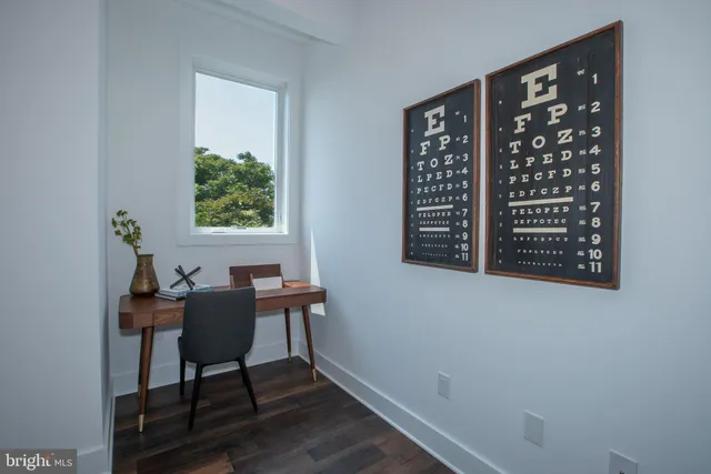a view of a workspace with furniture and a window