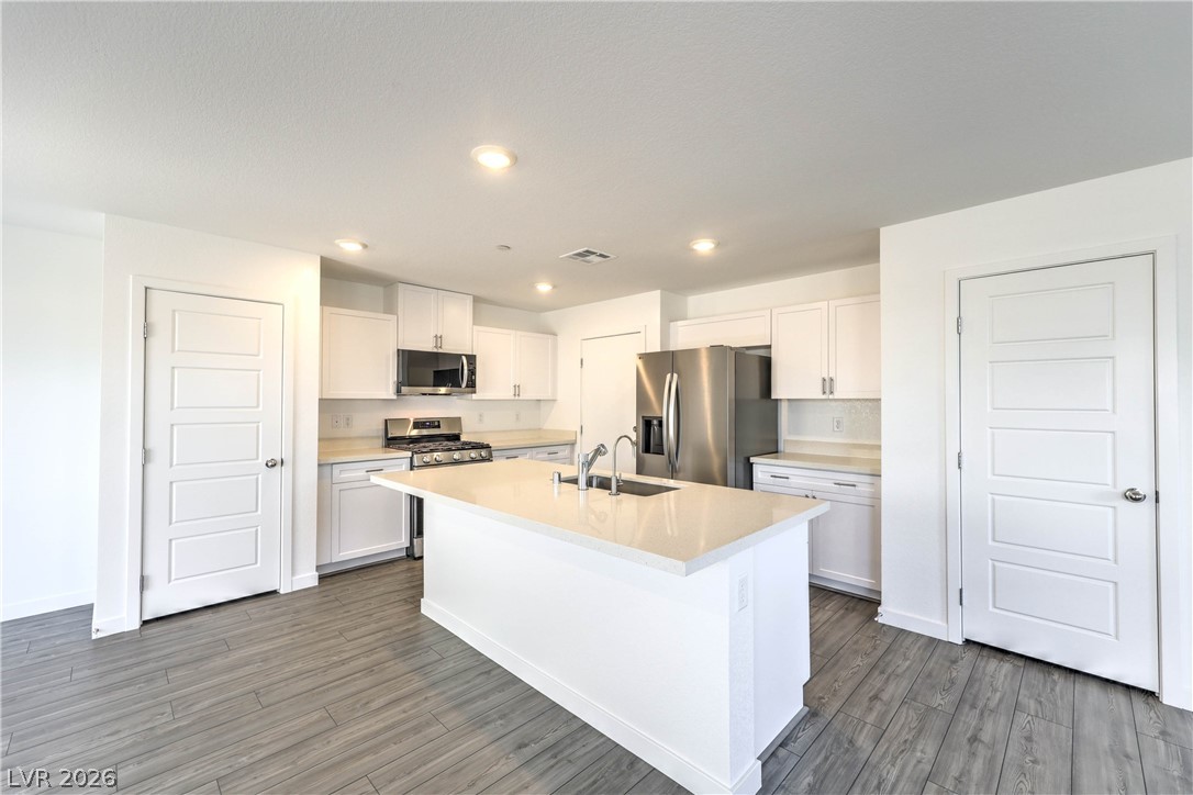 776 Fallen Phoenix Street Henderson, NV 89011 - Photo 7 of 30 Island Kitchen boasts Quartz Countertops, White Cabinets, Breakfast Bar, Pantry, 6 stage iSpring RO System, Recessed Lighting, and Stainless-Steel Gas Stove, Microwave, Dishwasher, and Refrigerator