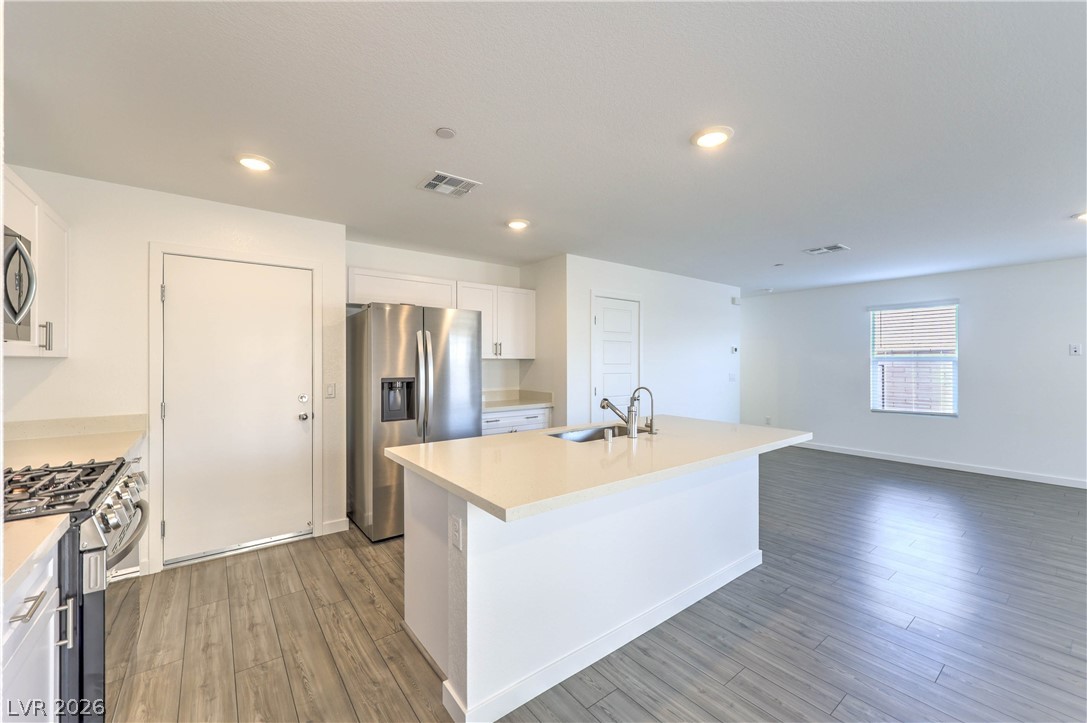 776 Fallen Phoenix Street Henderson, NV 89011 - Photo 10 of 30 Island Kitchen boasts Quartz Countertops, White Cabinets, Breakfast Bar, Pantry, 6 stage iSpring RO System, Recessed Lighting, and Stainless-Steel Gas Stove, Microwave, Dishwasher, and Refrigerator