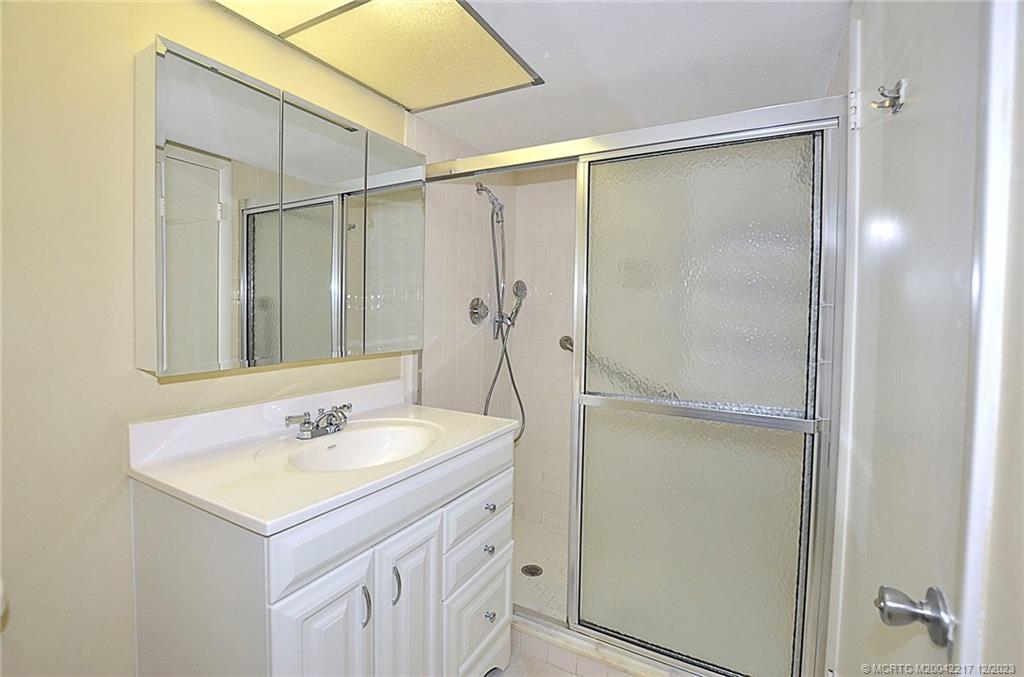 1866 Southwest Palm City Road, Unit 302 Stuart, FL 34994 - Photo 15 of 30 a bathroom with a shower sink and mirror