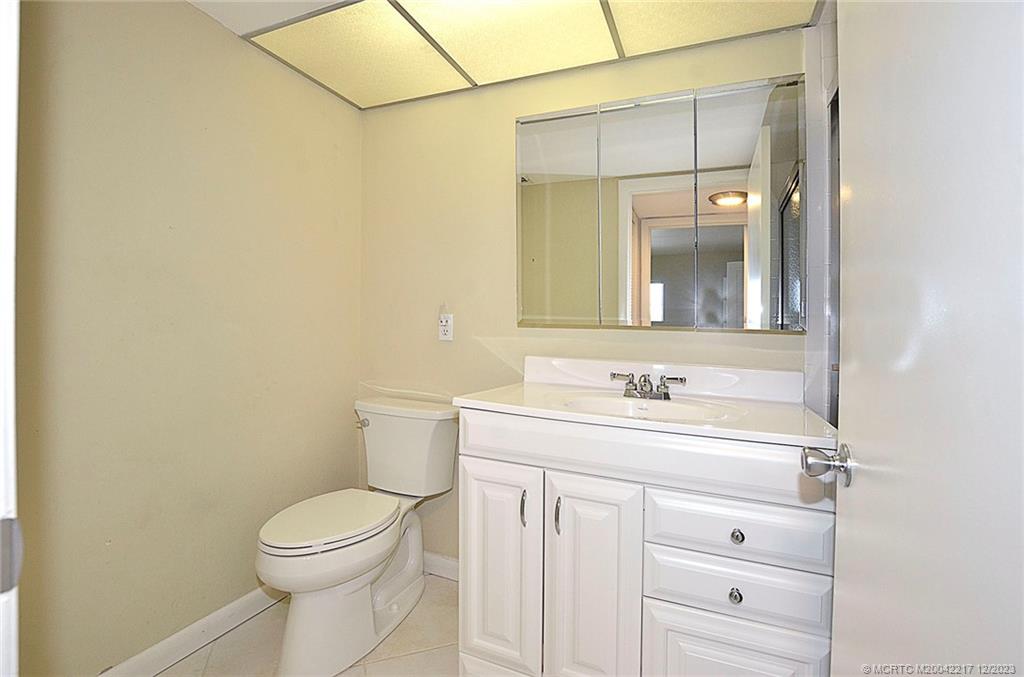 1866 Southwest Palm City Road, Unit 302 Stuart, FL 34994 - Photo 16 of 30 a bathroom with a toilet a sink and mirror