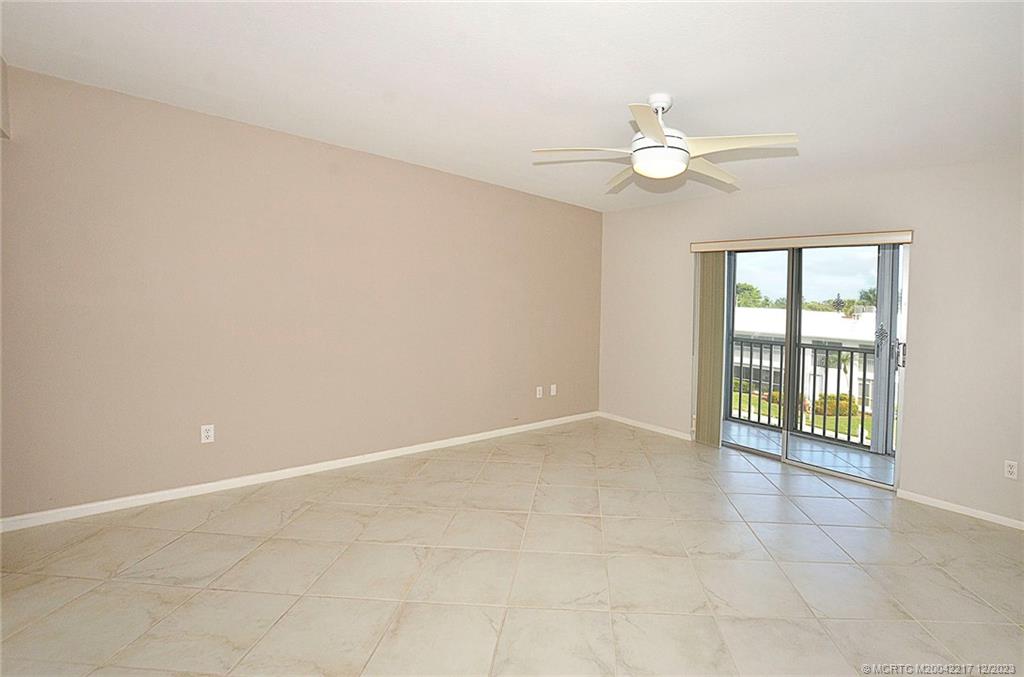 1866 Southwest Palm City Road, Unit 302 Stuart, FL 34994 - Photo 25 of 30 an empty room with chandelier fan and windows