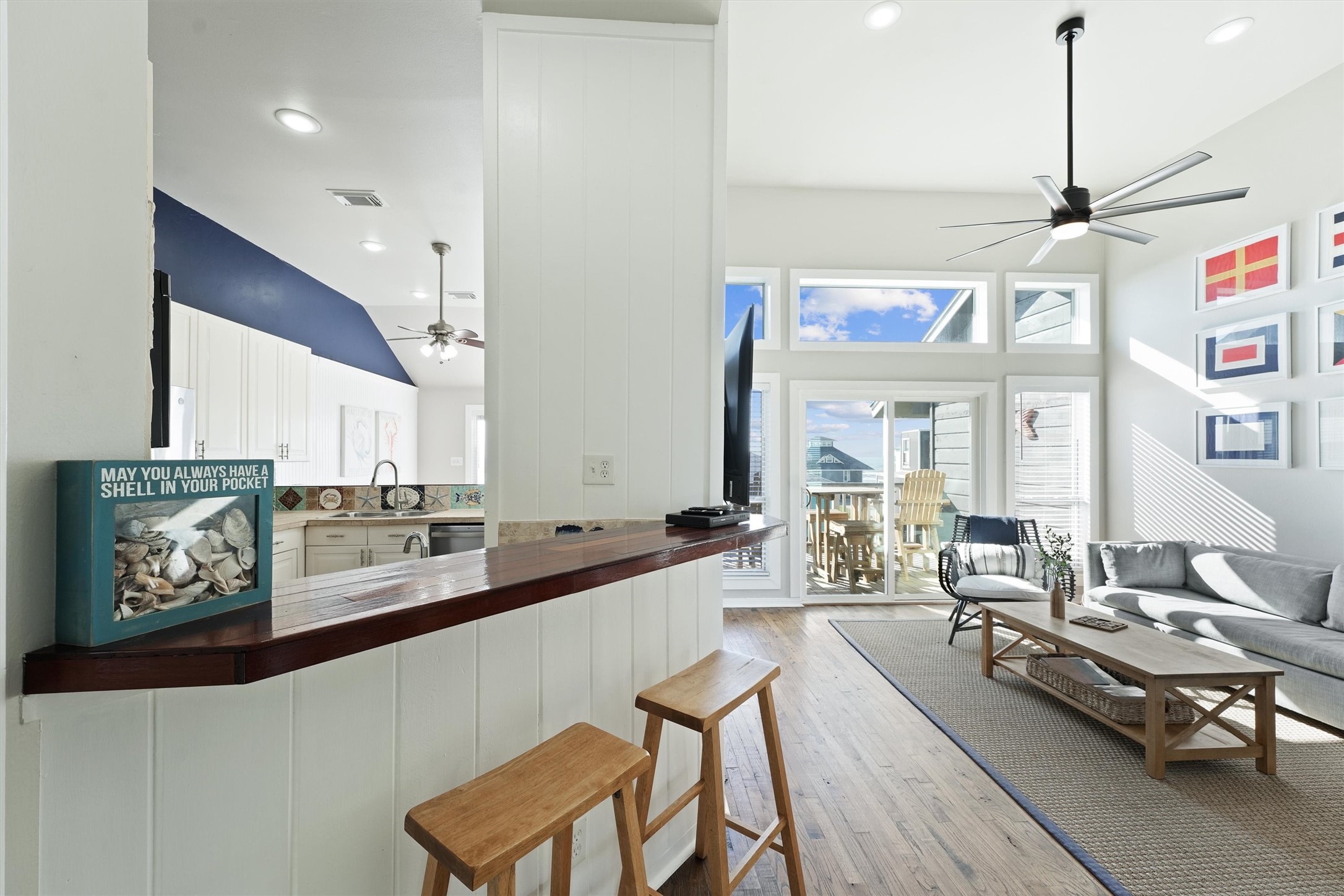 17607 Termini-San Luis Pass Road Galveston, TX 77554 - Photo 5 of 42 The kitchen flows effortlessly into the living area, with a stylish bar counter that provides a perfect spot for casual dining or entertaining. The light wood and white color scheme enhance the airy, beach-inspired atmosphere.
