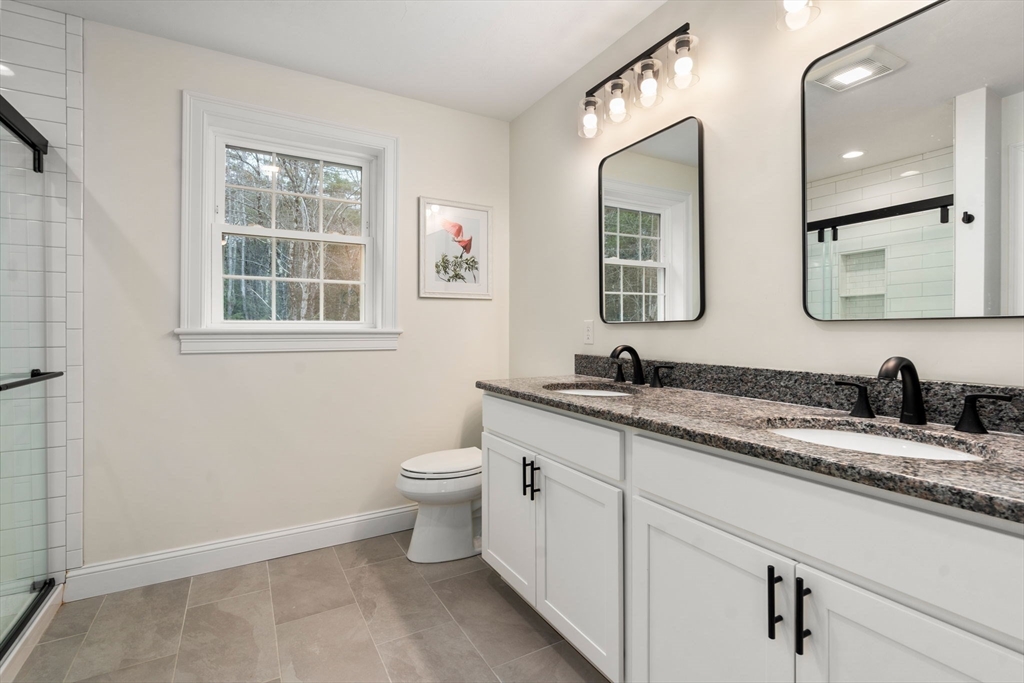 813 Chase Road Lunenburg, MA 01462 - Photo 21 of 41 a bathroom with a granite countertop toilet sink and mirror