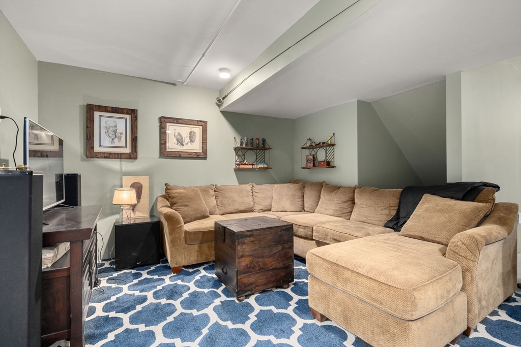 813 Chase Road Lunenburg, MA 01462 - Photo 26 of 41 a living room with furniture and a flat screen tv