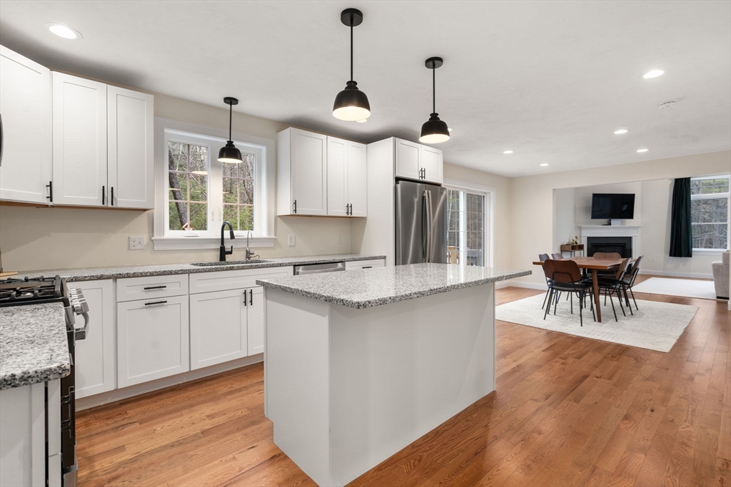 813 Chase Road Lunenburg, MA 01462 - Photo 3 of 41 a kitchen with stainless steel appliances granite countertop a sink a stove a refrigerator and island with wooden floor