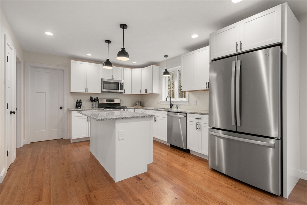 813 Chase Road Lunenburg, MA 01462 - Photo 4 of 41 a kitchen with stainless steel appliances a refrigerator a sink cabinets a wooden floor and a sink