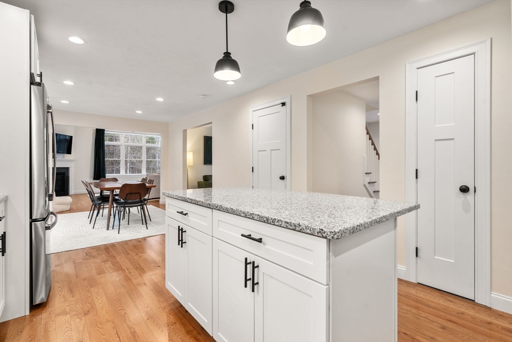 813 Chase Road Lunenburg, MA 01462 - Photo 6 of 41 a view of a kitchen center island wooden floor and living room