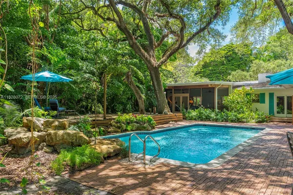 a view of a house with backyard sitting area and garden