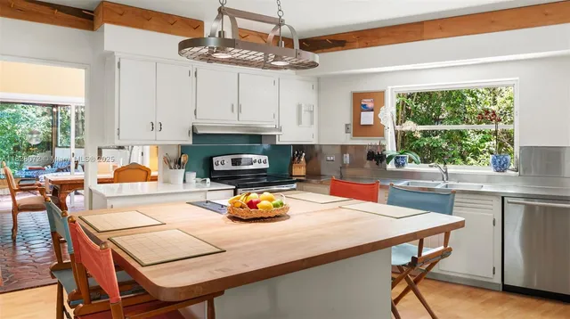 a kitchen with a stove a table and chairs in it