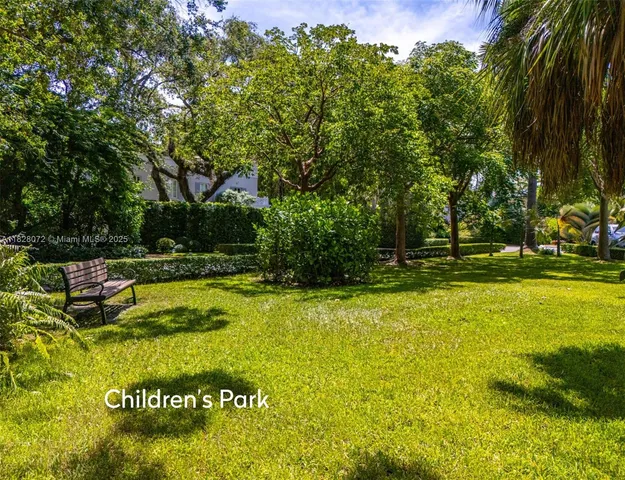 a view of swimming pool with lawn chairs and large trees
