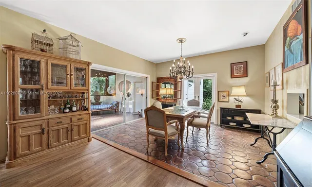 a living room with furniture a chandelier and wooden floor