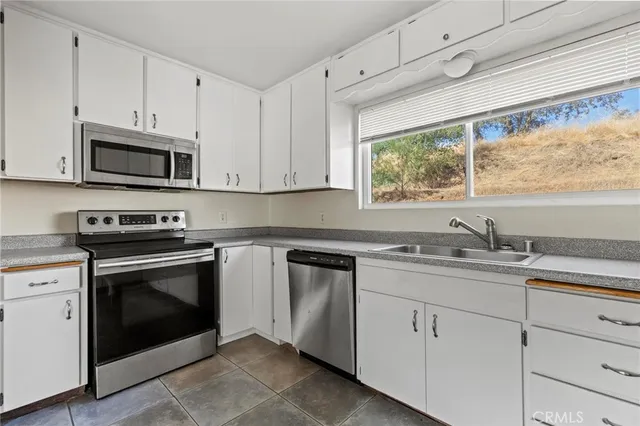 a kitchen with granite countertop white cabinets and a stove
