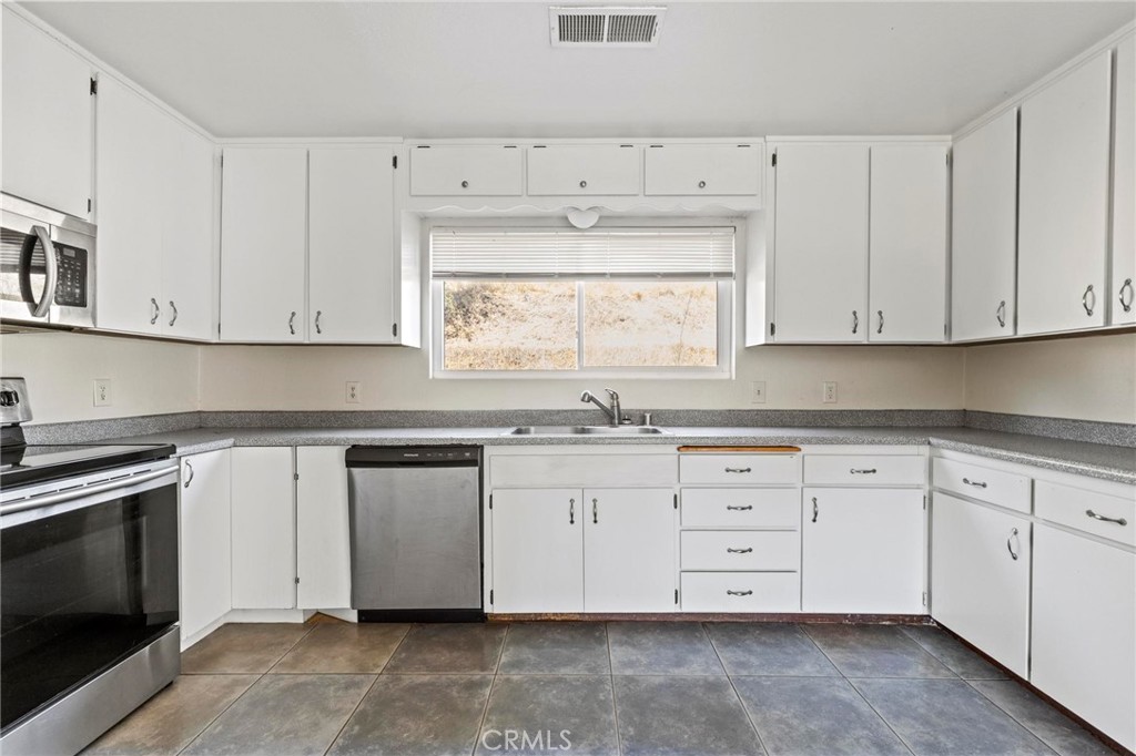 3305 Grubbs Road Oroville, CA 95966 - Photo 13 of 43 a kitchen with granite countertop white cabinets and a stove