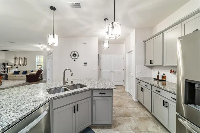 a kitchen with stainless steel appliances granite countertop a stove a refrigerator and a white cabinets