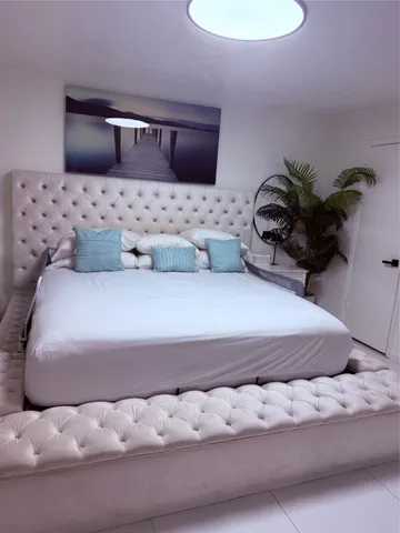 a bedroom with a bed and a potted plant