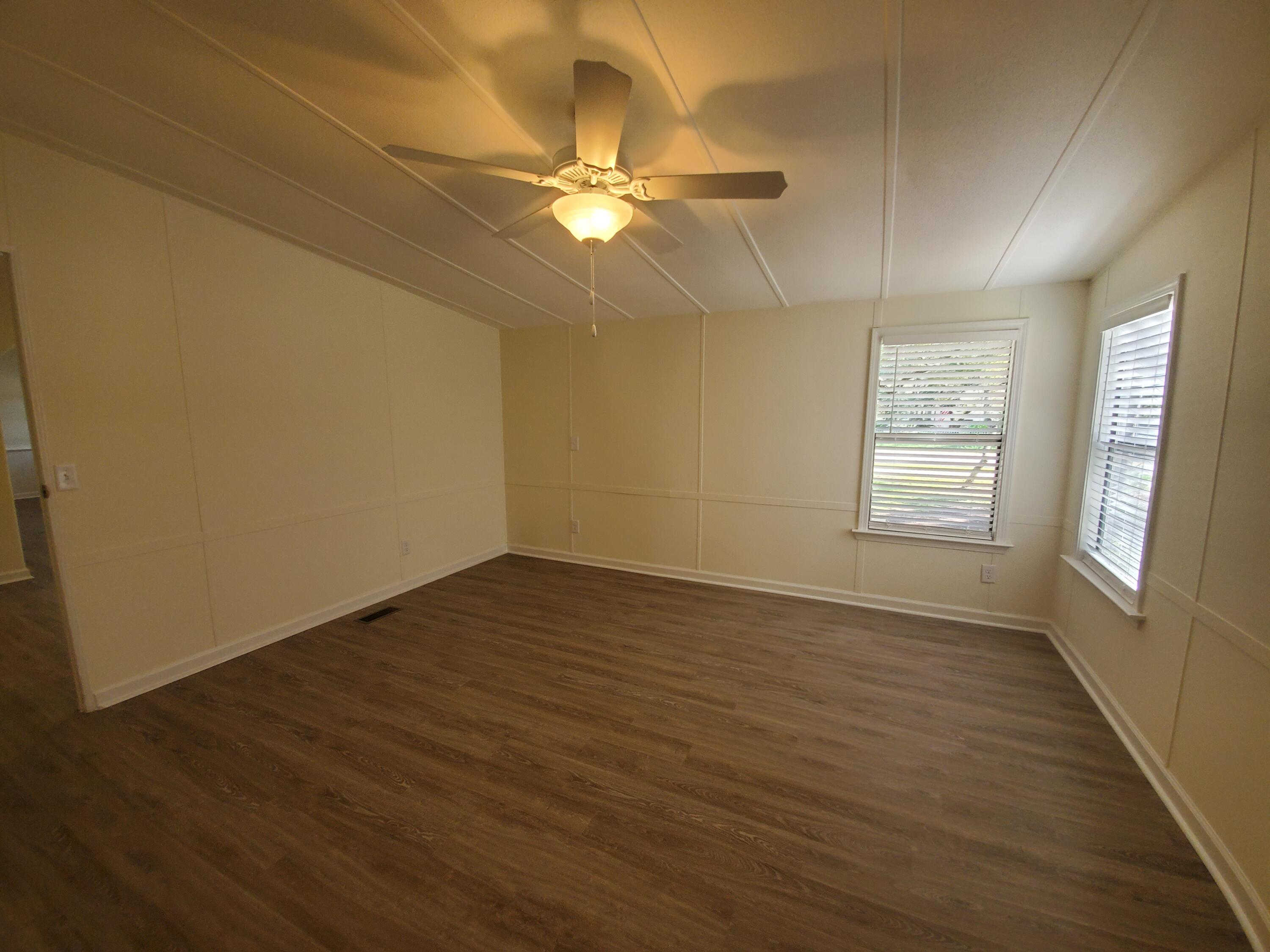 990 Chat Holley Road Santa Rosa Beach, FL 32459 - Photo 12 of 25 a view of an empty room with wooden floor and a window