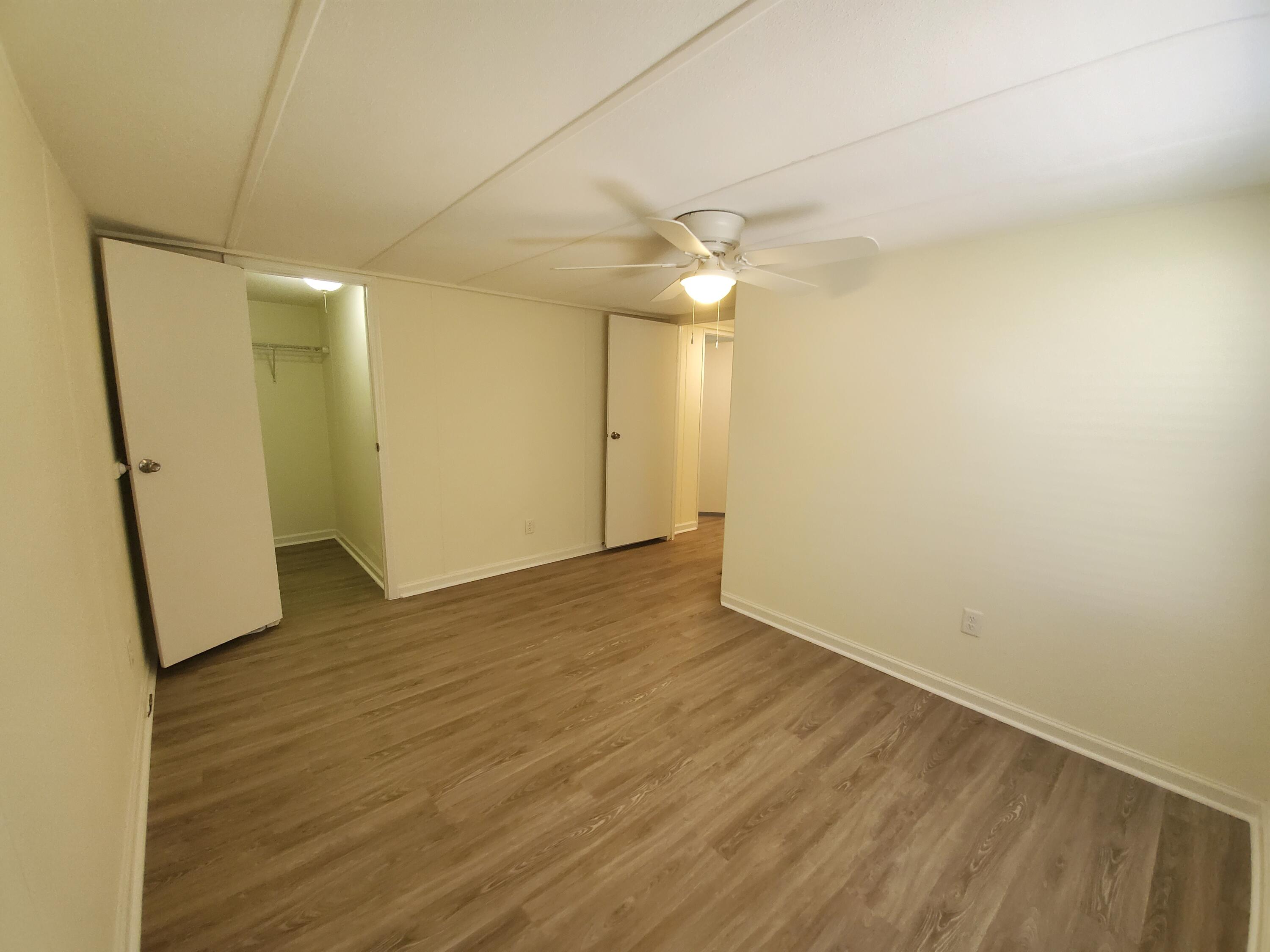 990 Chat Holley Road Santa Rosa Beach, FL 32459 - Photo 15 of 25 an empty room with wooden floor and a ceiling fan