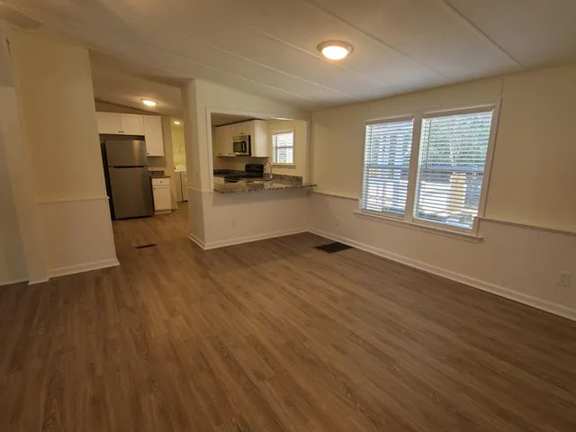 a view of a kitchen with a sink a refrigerator and a window