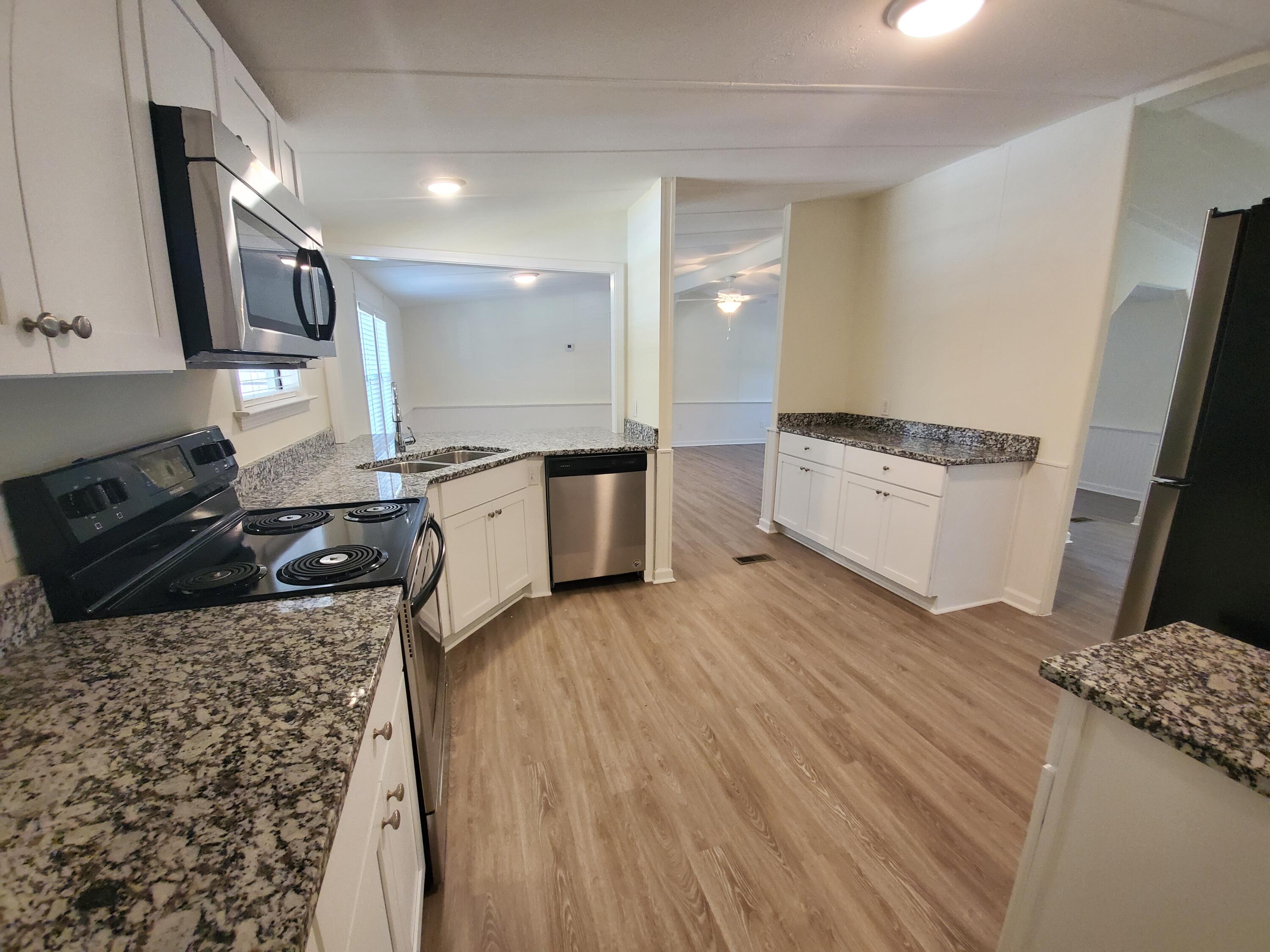 990 Chat Holley Road Santa Rosa Beach, FL 32459 - Photo 10 of 25 a kitchen with granite countertop a sink stove and refrigerator