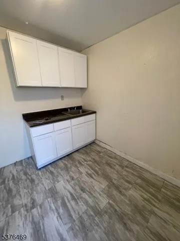 a kitchen with granite countertop white cabinets and a stove